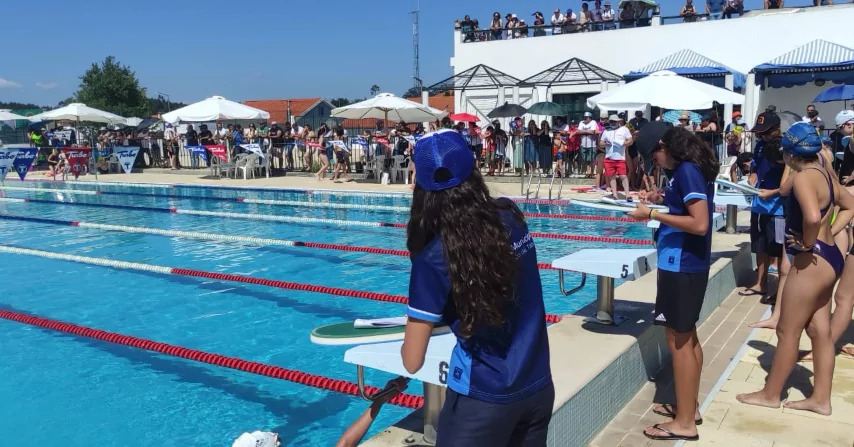Organização conversa com participantes junto à piscina