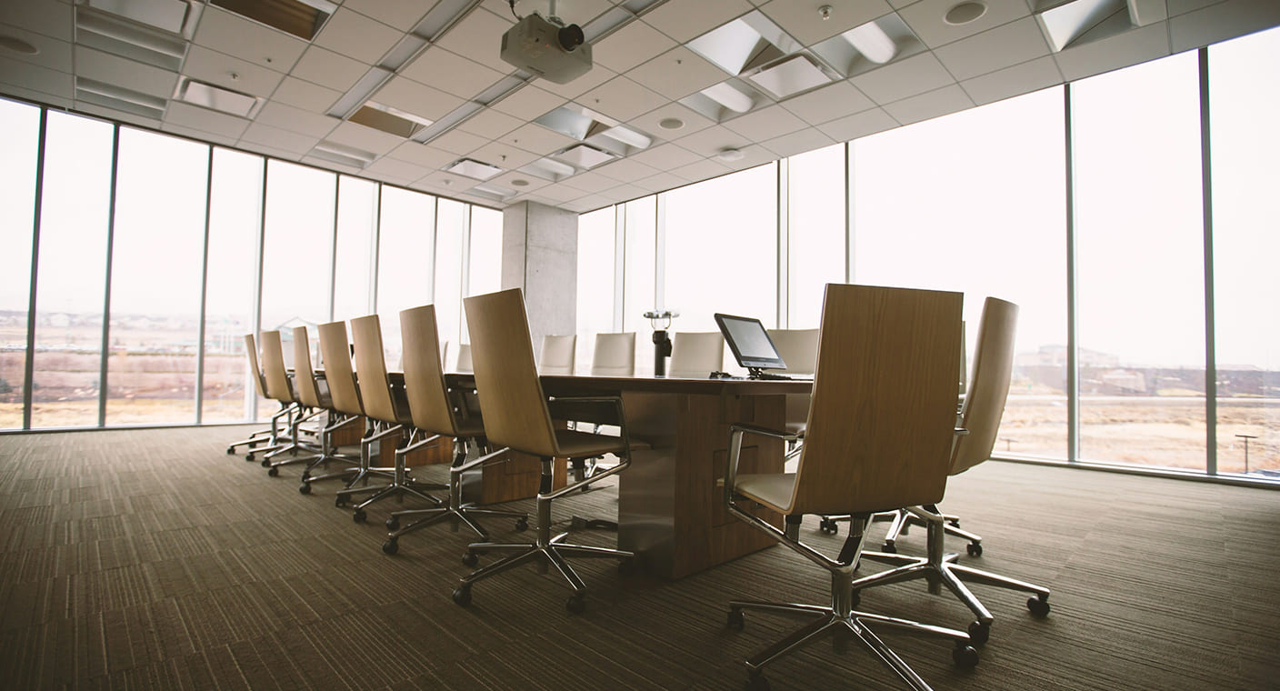 Sala de reuniões com mesa comprida e cadeiras