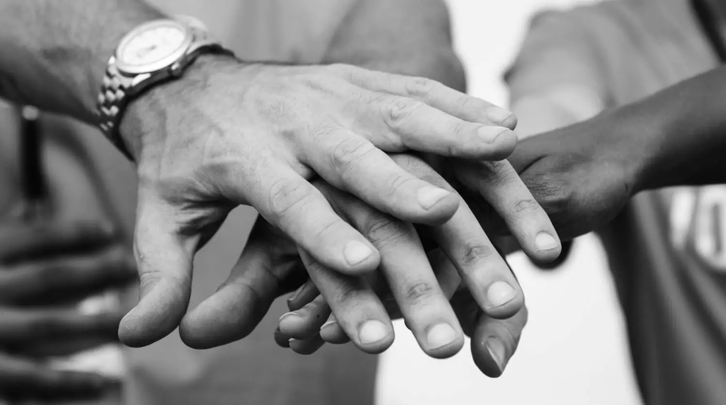 Mãos sobrepostas representam apoio e solidariedade social