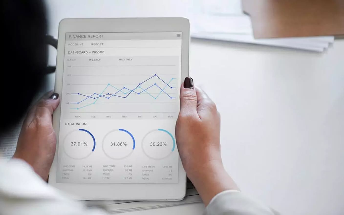 Pessoa consulta gráficos financeiros num tablet