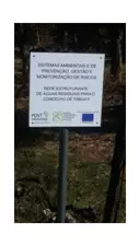 Placa informativa de projeto instalada numa área arborizada