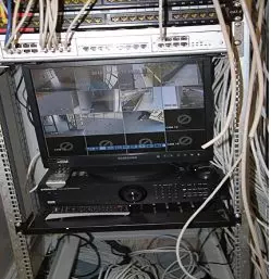 Equipamento de rede e monitor instalados num armário técnico