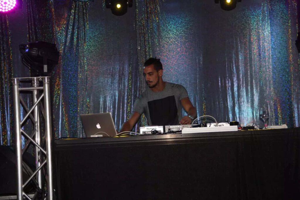 Disc jockey atua atrás da mesa de mistura