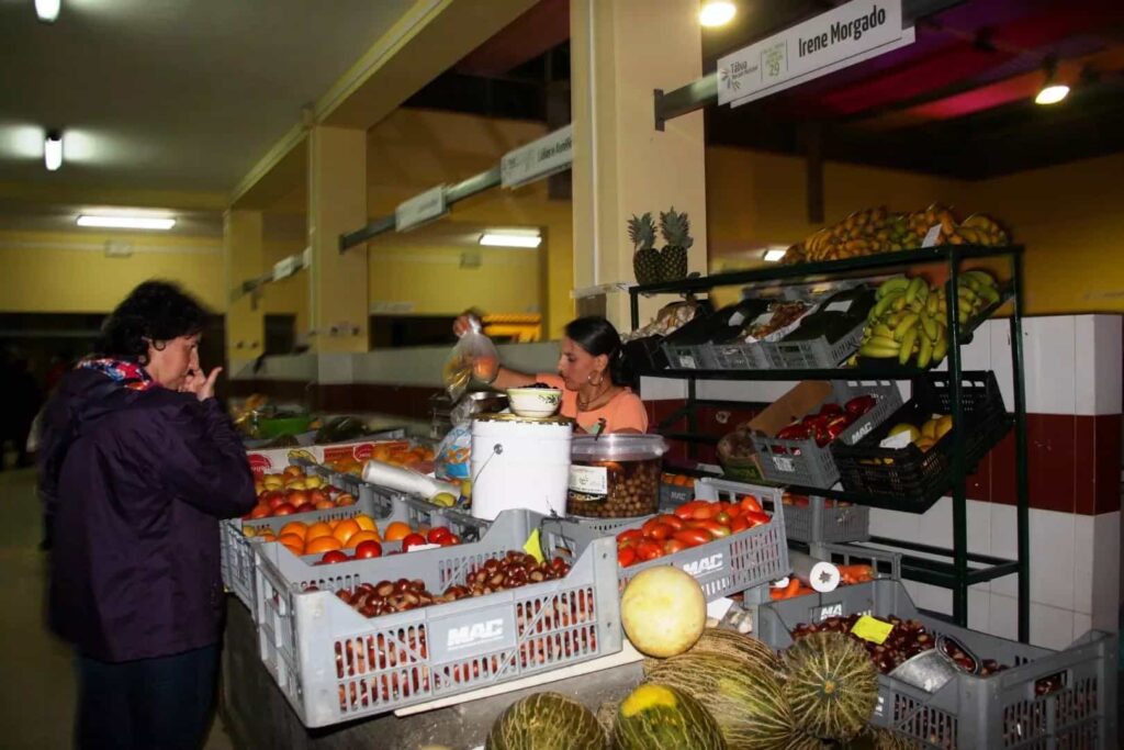 Vendedora organiza fruta numa banca do Mercado Municipal