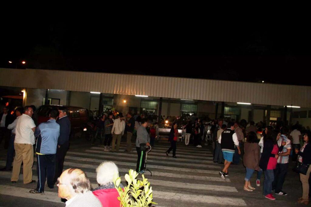Público reunido à noite no exterior do Mercado Municipal