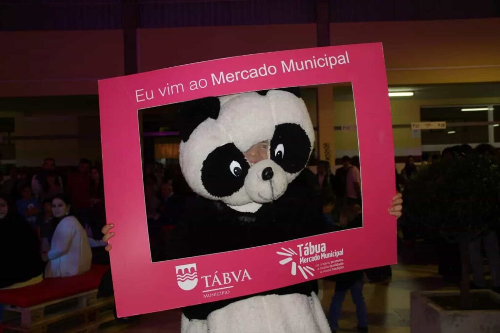 Mascote panda posa na moldura Eu vim ao Mercado Municipal
