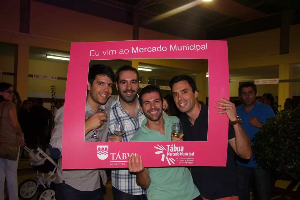 Quatro jovens posam na moldura Eu vim ao Mercado Municipal