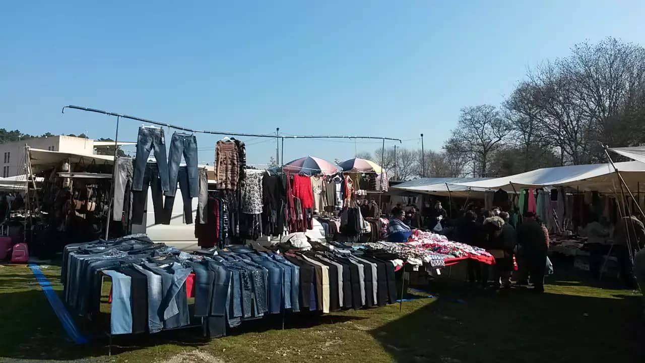 Bancas de calças e roupa numa feira ao ar livre