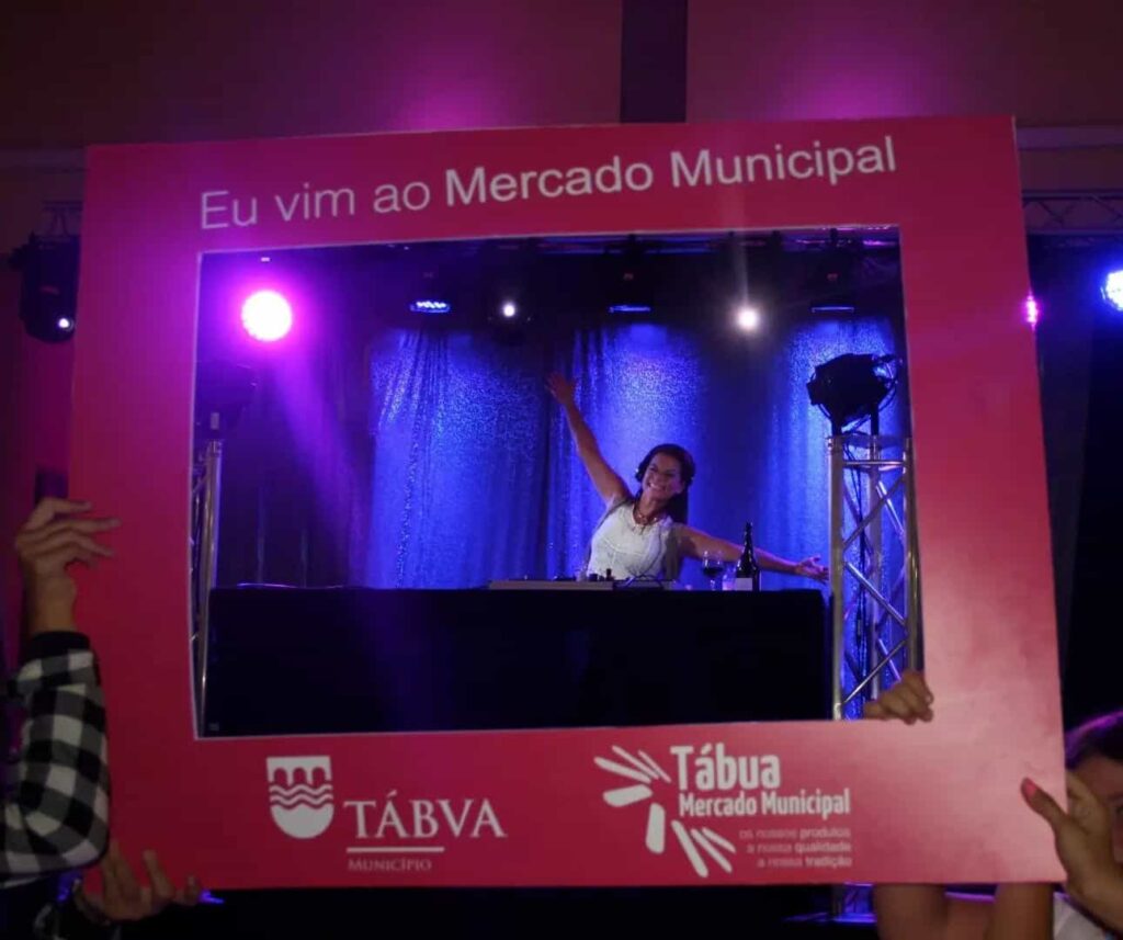 Artista no palco segura a moldura Eu vim ao Mercado Municipal