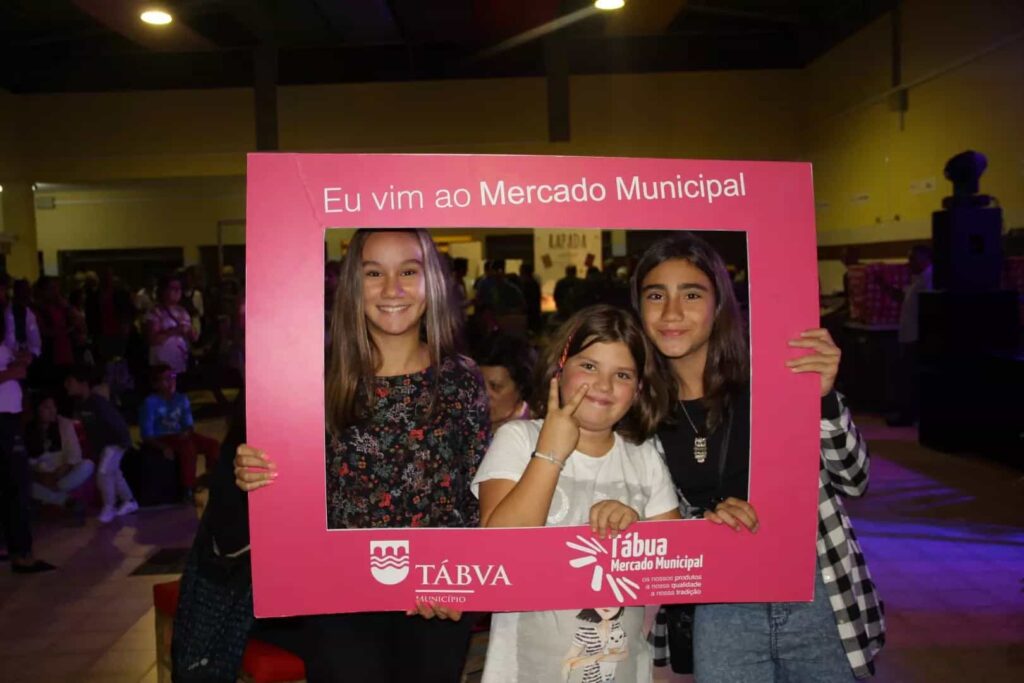 Três crianças posam na moldura Eu vim ao Mercado Municipal