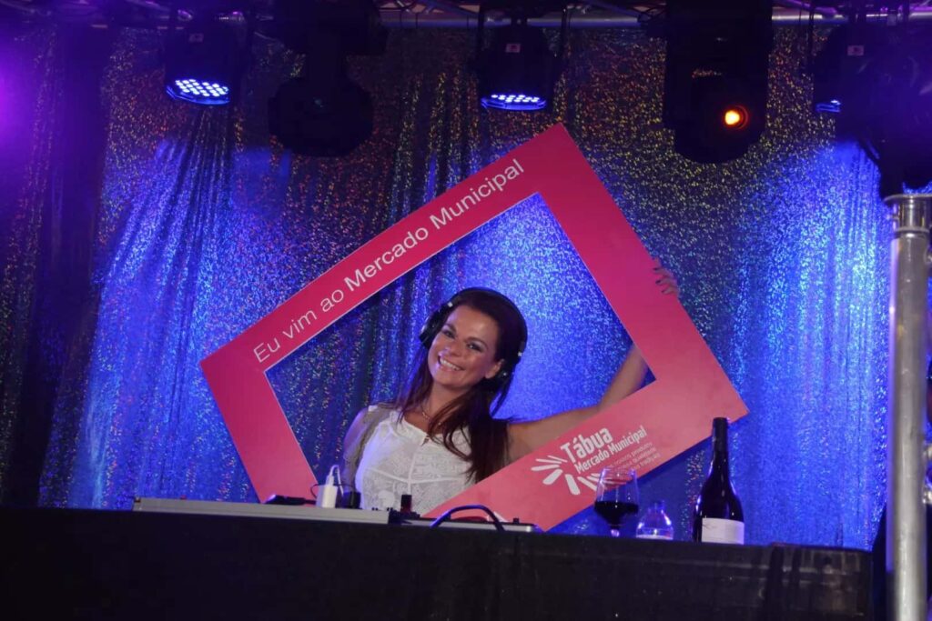 Artista posa no palco com a moldura Eu vim ao Mercado Municipal