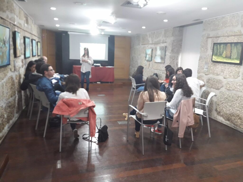 Participantes assistem a uma apresentação numa sala de pedra