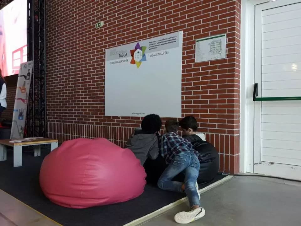 Três jovens consultam uma projeção do Projeto Educativo Local