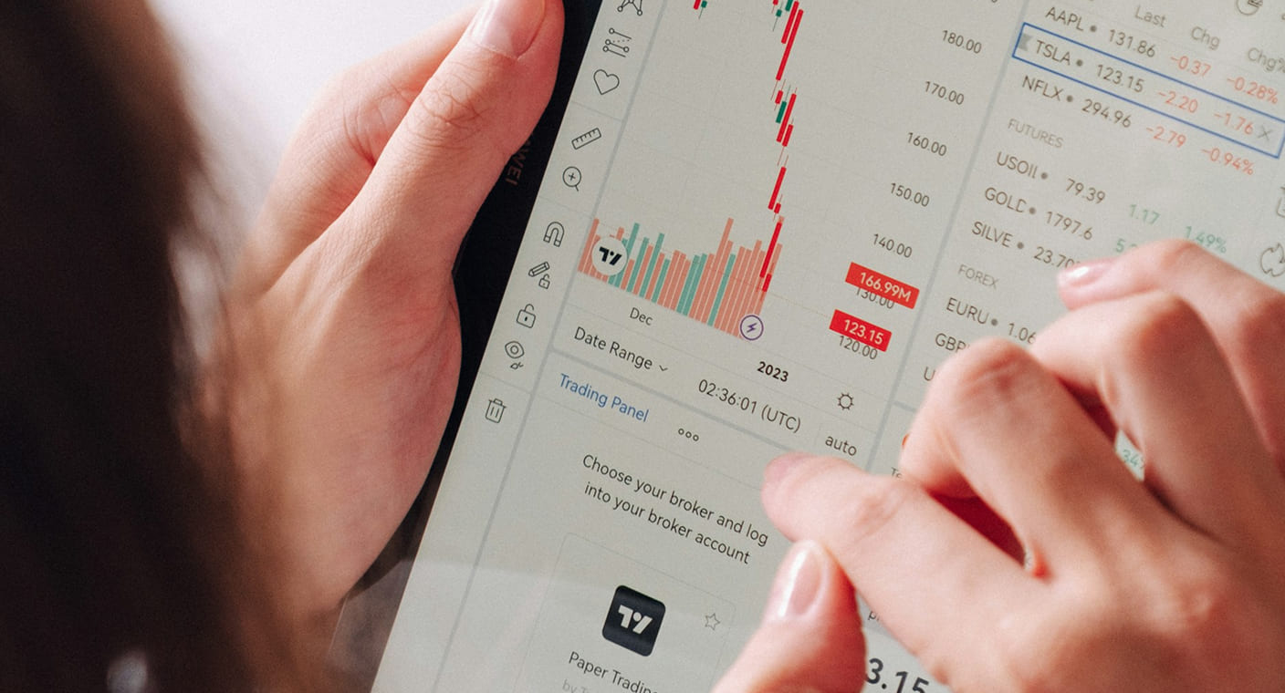 Pessoa consulta indicadores financeiros num tablet