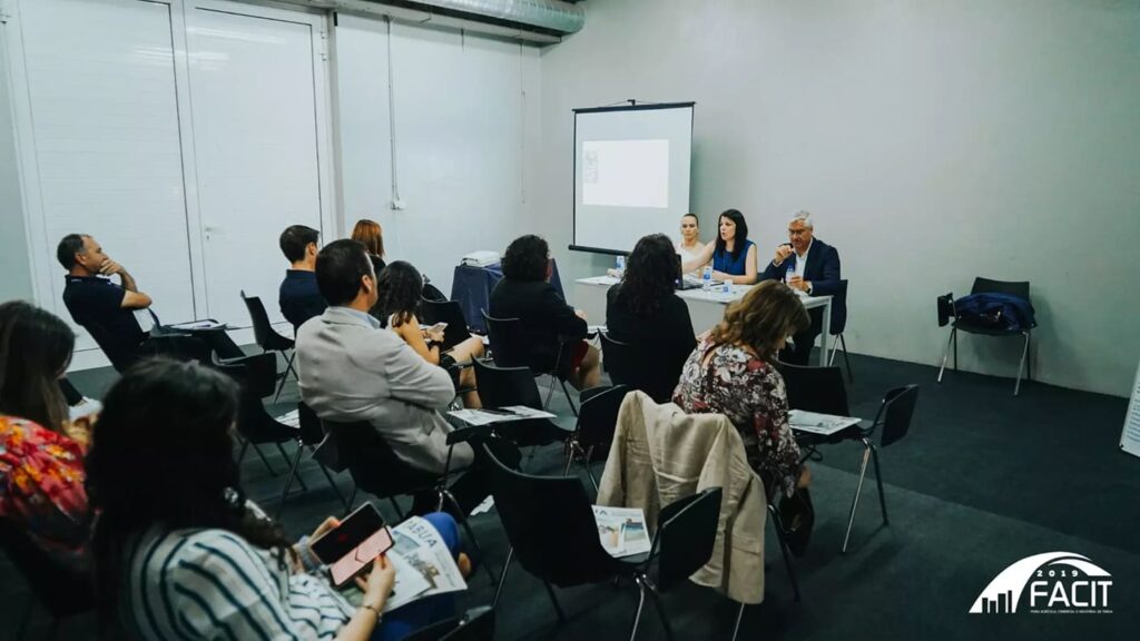 Participantes assistem a uma apresentação numa sala de reuniões