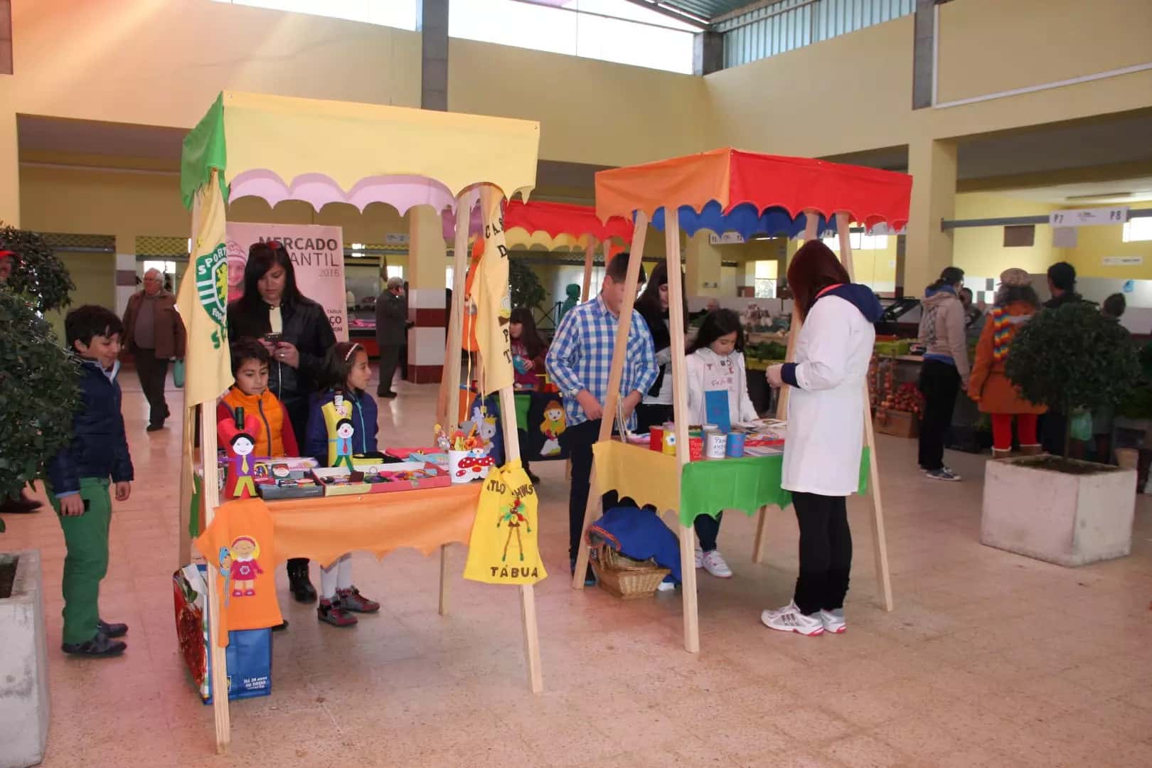Crianças e adultos numa banca colorida do Mercado Infantil