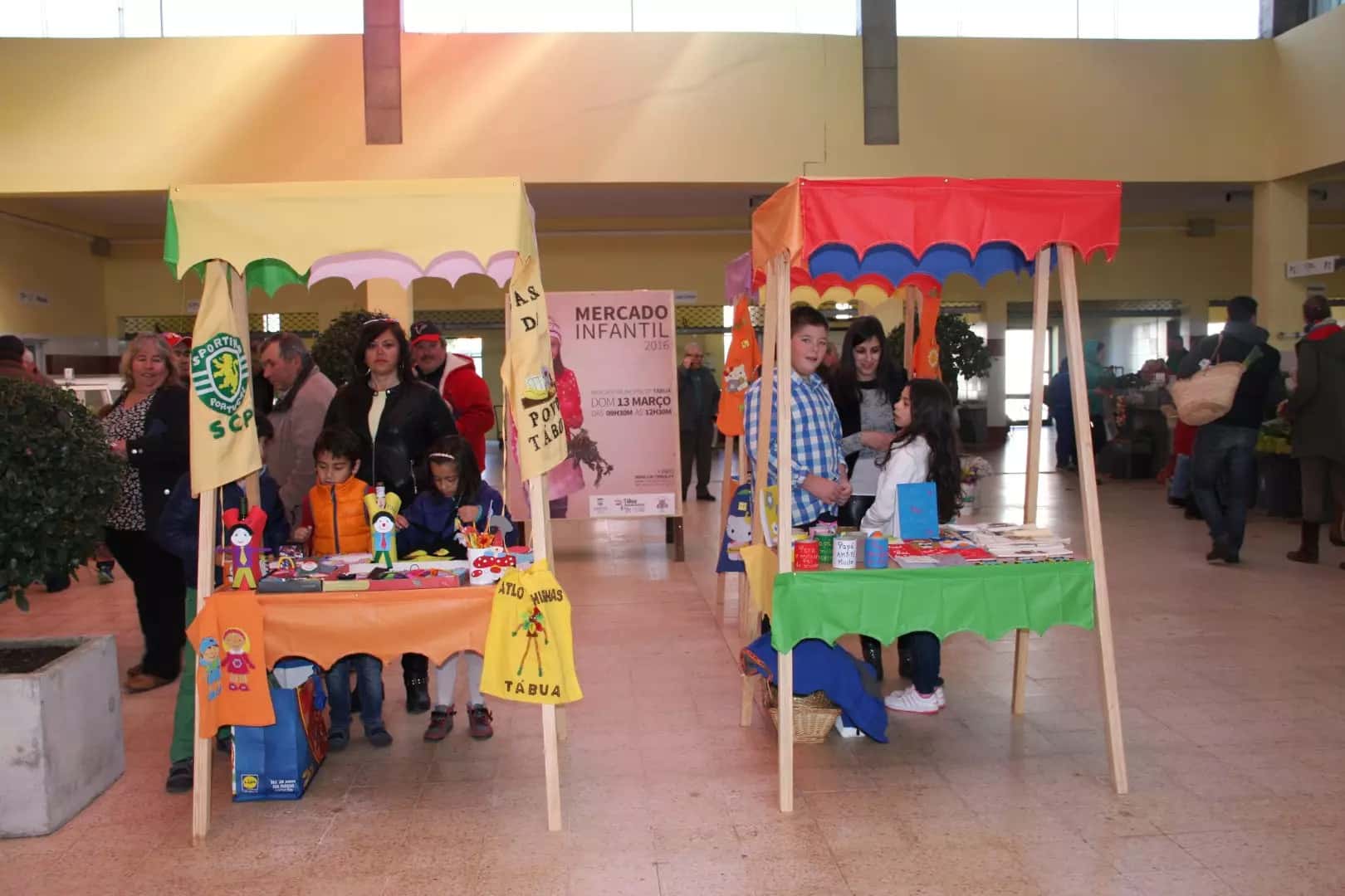 Participantes reunidos junto a uma banca do Mercado Infantil