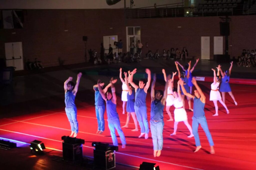 Grupo de ginastas conclui uma coreografia no pavilhão