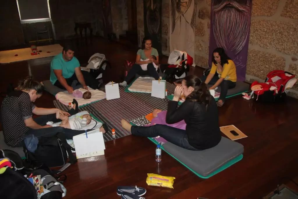 Pais e mães reunidos no curso de massagem infantil na Biblioteca Pública Municipal de Tábua
