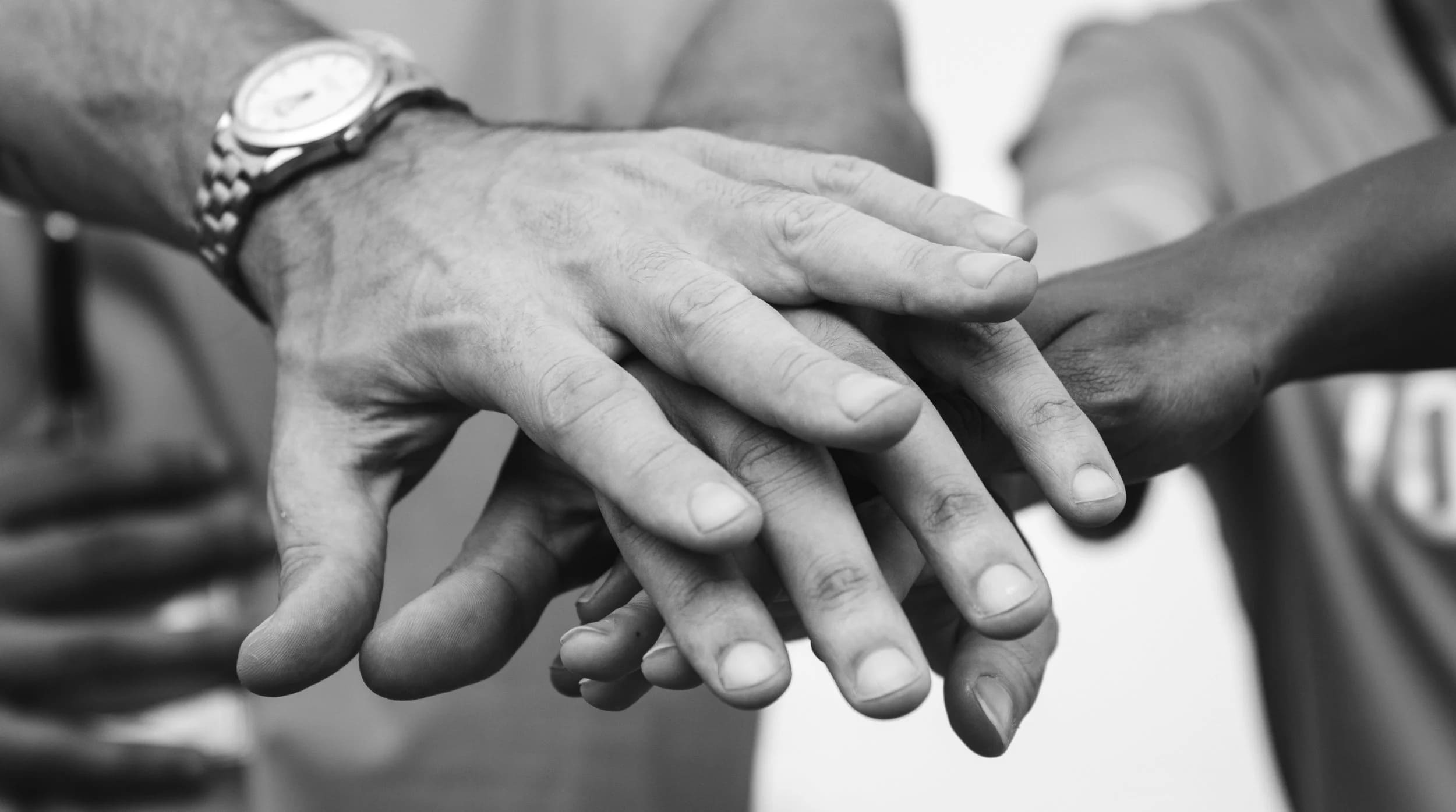 Mãos sobrepostas representam apoio e solidariedade social