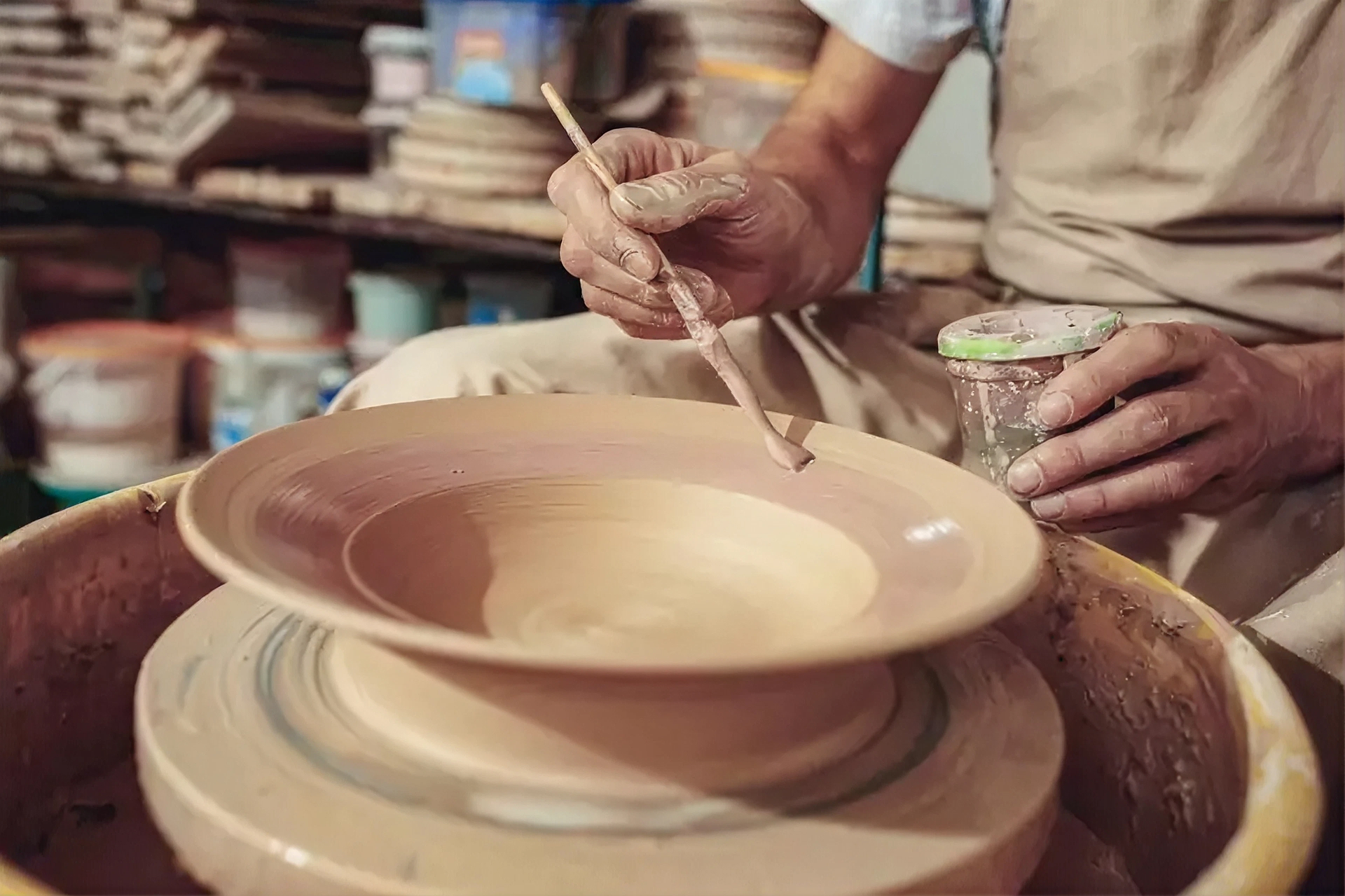 Artesão molda uma peça de barro numa roda de oleiro