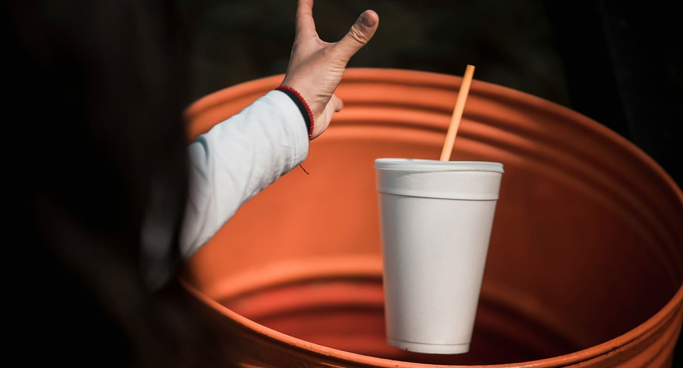 Copo descartável colocado num recipiente para recicláveis