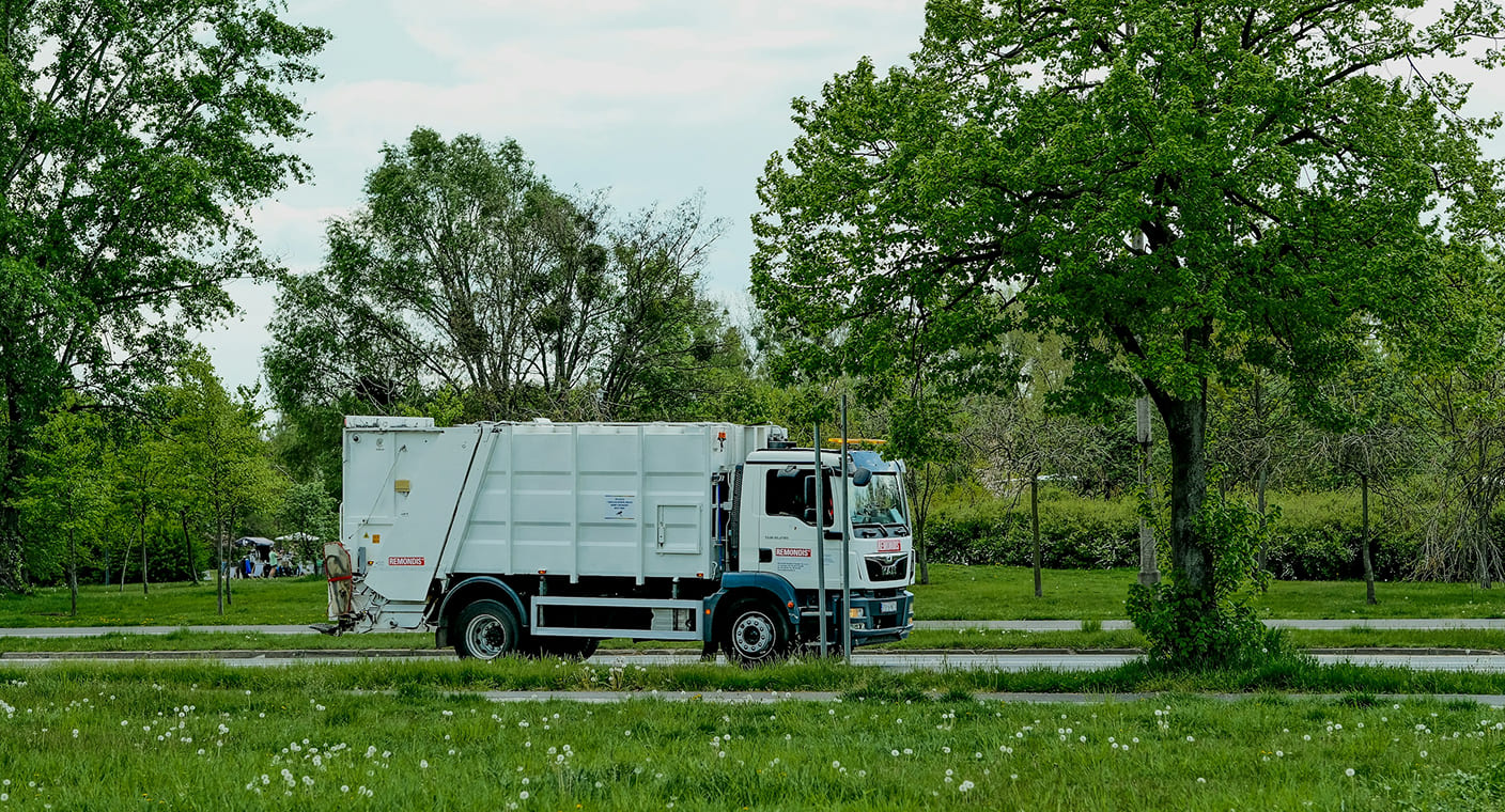 Camião de recolha de resíduos urbanos numa zona verde